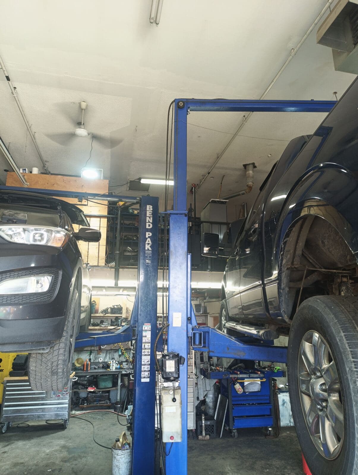 Pickup truck raised on a blue two-post hoist in the TNT Transmission bay
