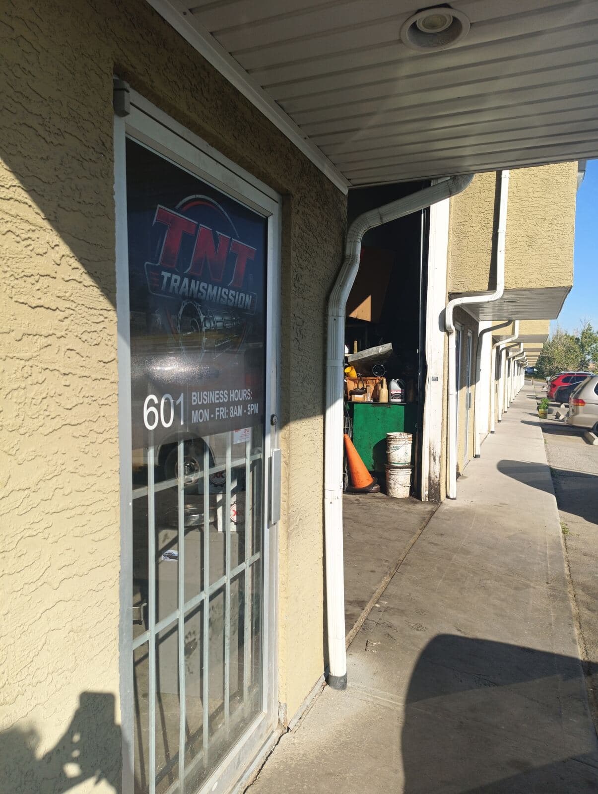 TNT Transmission front door, unit 601, with the logo decal and business hours